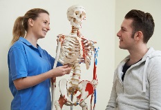 A photo of an osteopath explaining treatment to a patient