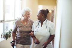 A nurse walks and supports a patient